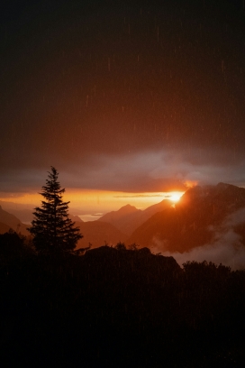 雨幕中山峰落日熔金 冷暖光影交织山野治愈氛围感
