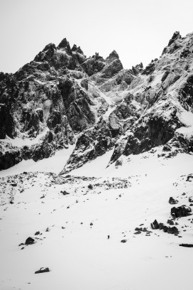 黑白纪实风格雪山群峰下渺小徒步者的山野自然图景